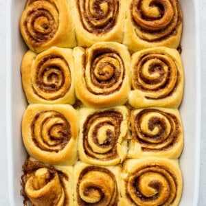 Baked orange rolls in a casserole dish.