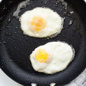 Two fried eggs in a frying pan.