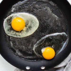 Two fried eggs in a frying pan.