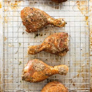 Roasted chicken legs on a cooling rack.