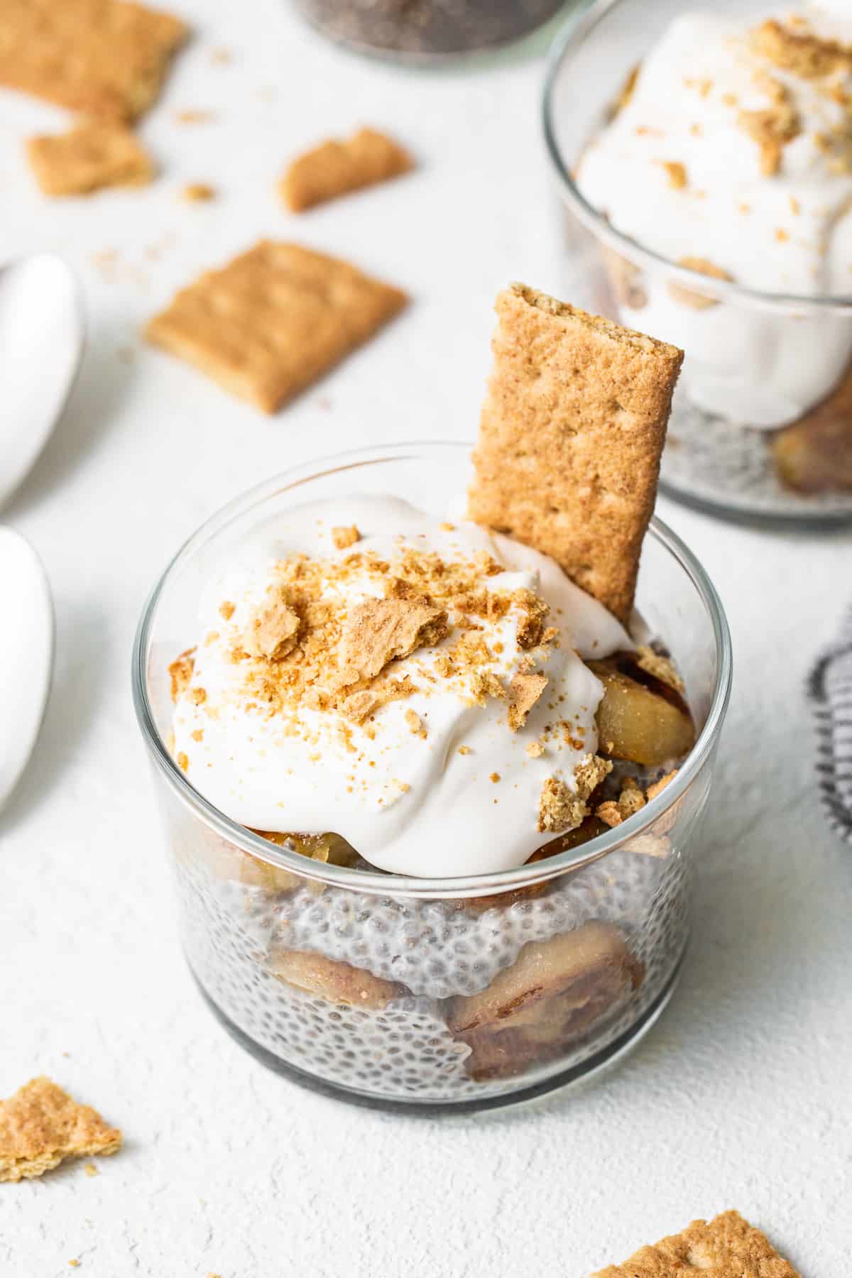 Banana cream pie chia seed pudding in a glass topped with graham crackers.