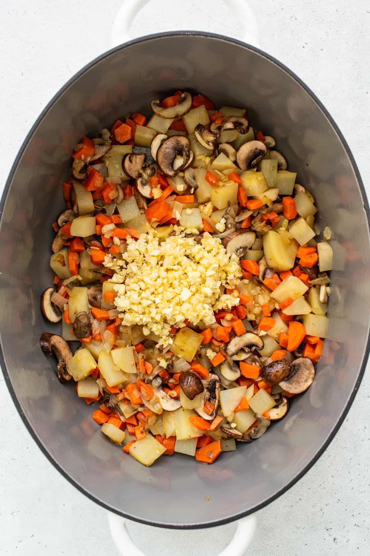 Minced garlic and vegetables in a le cruset. 