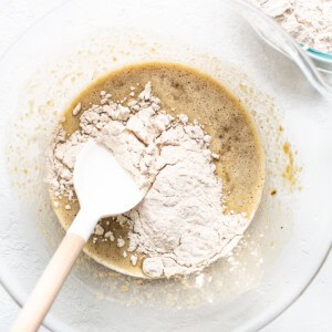 adding dry ingredients to wet in bowl.