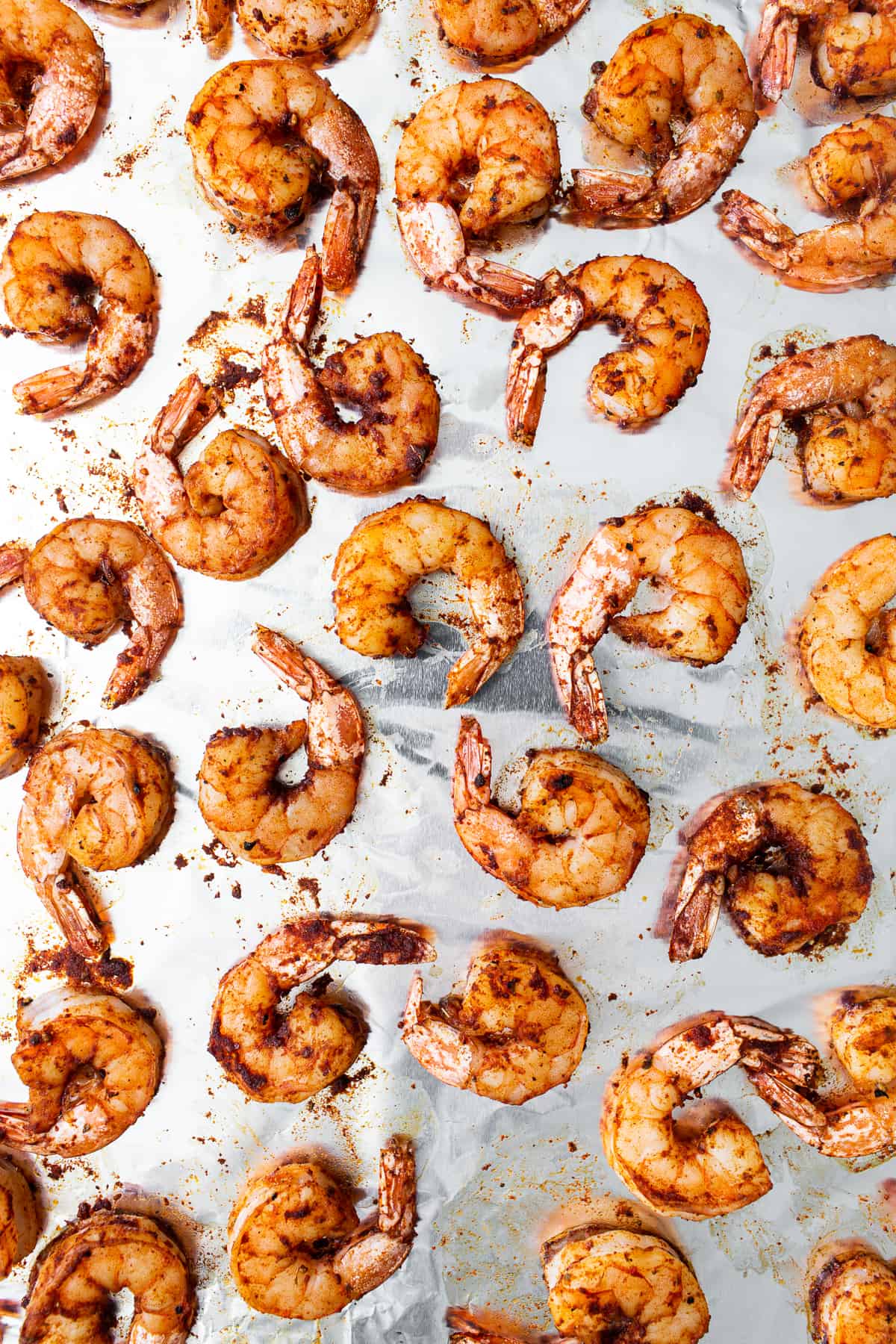 Broiled shrimp on a baking sheet.