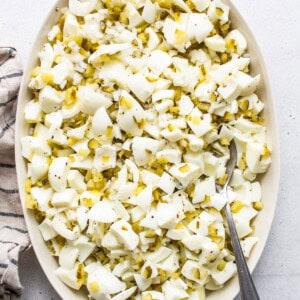 A bowl of shredded cabbage with a spoon on a table.