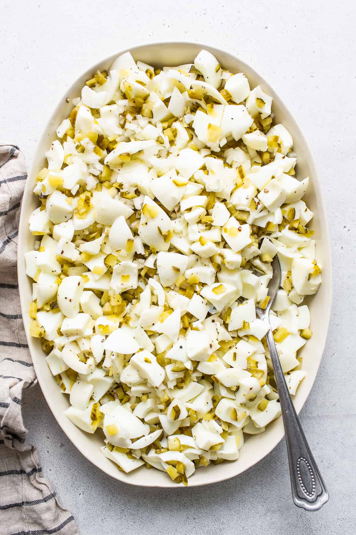 Chopped egg whites in a bowl with a spoon.