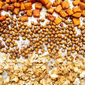 Butternut squash, chickpeas, and cauliflower on a baking sheet.