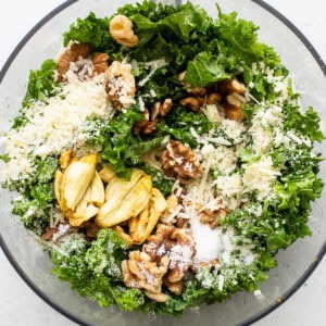 All of the ingredients for kale pesto in a food processor.