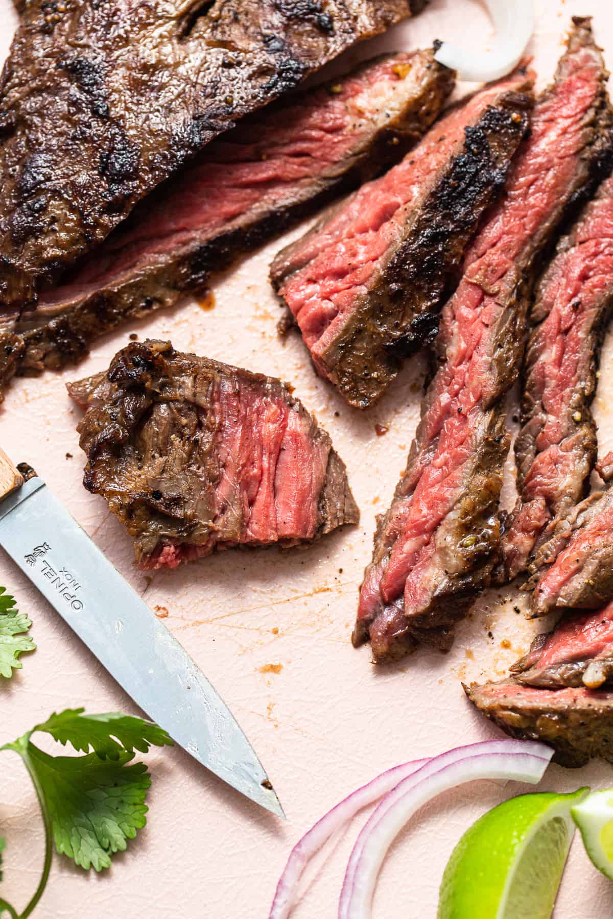 Sliced of skirt steak and a knife.