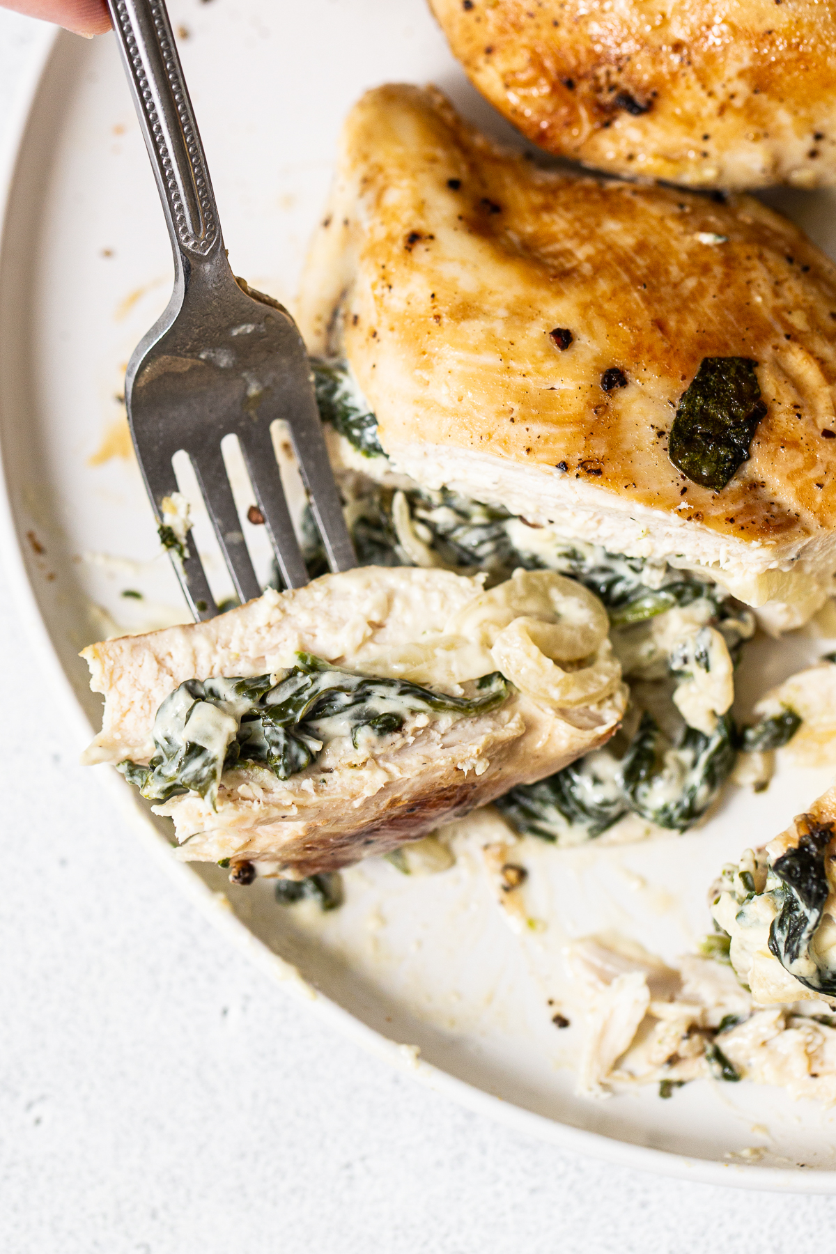 Slice of a spinach stuffed chicken breast on a plate.