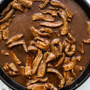 cooking beef in sauce in pan.