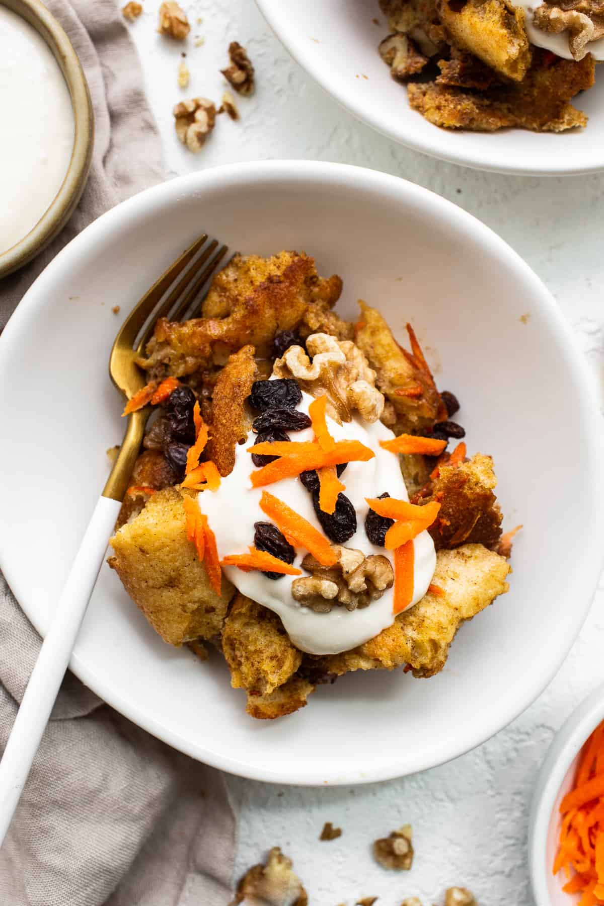 Serving of carrot cake french toast casserole on a plate with a fork.