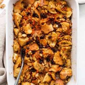 A white baking dish filled with bread and carrots.