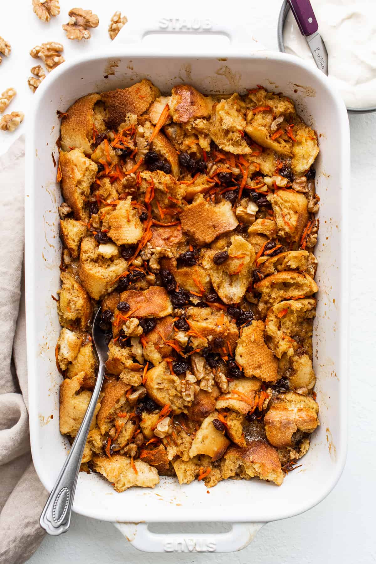 A spoon in a casserole dish of carrot cake french toast casserole.