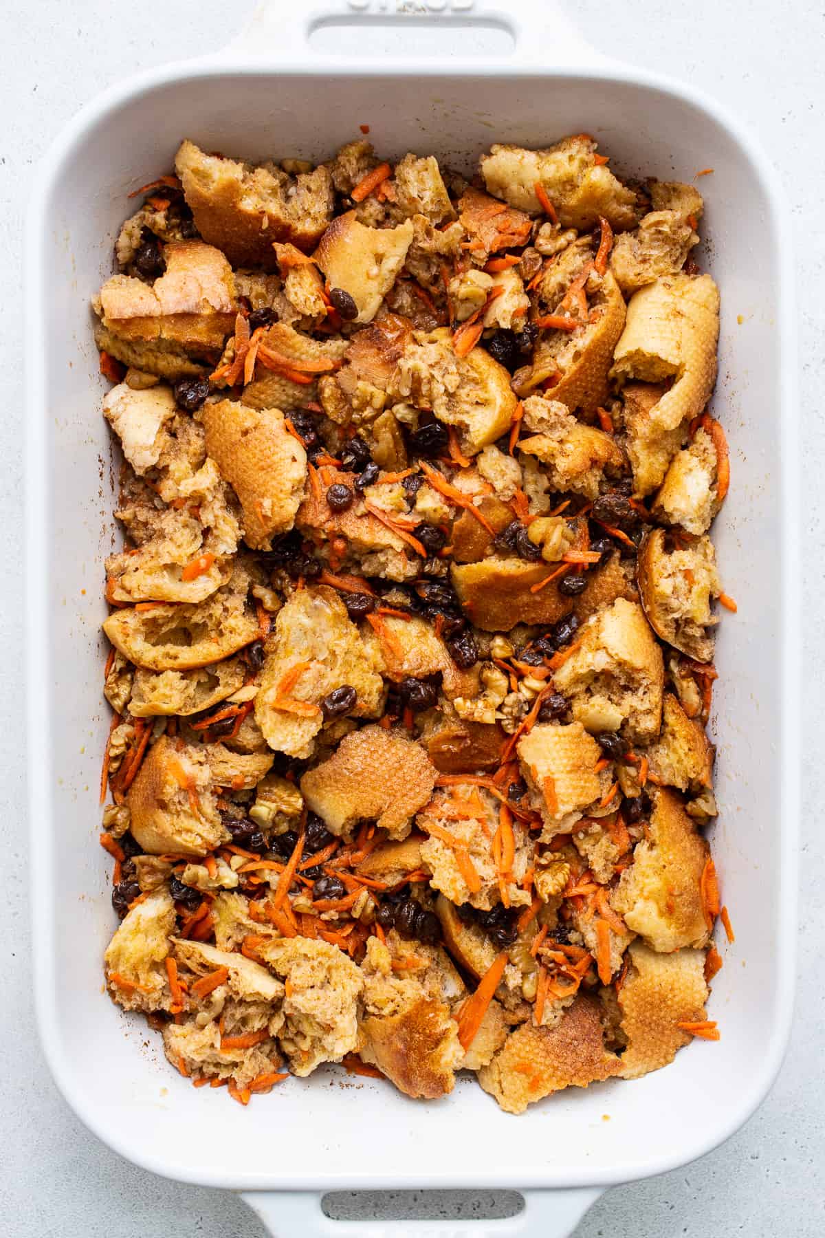 Carrot cake french toast casserole mixed together in a casserole dish.