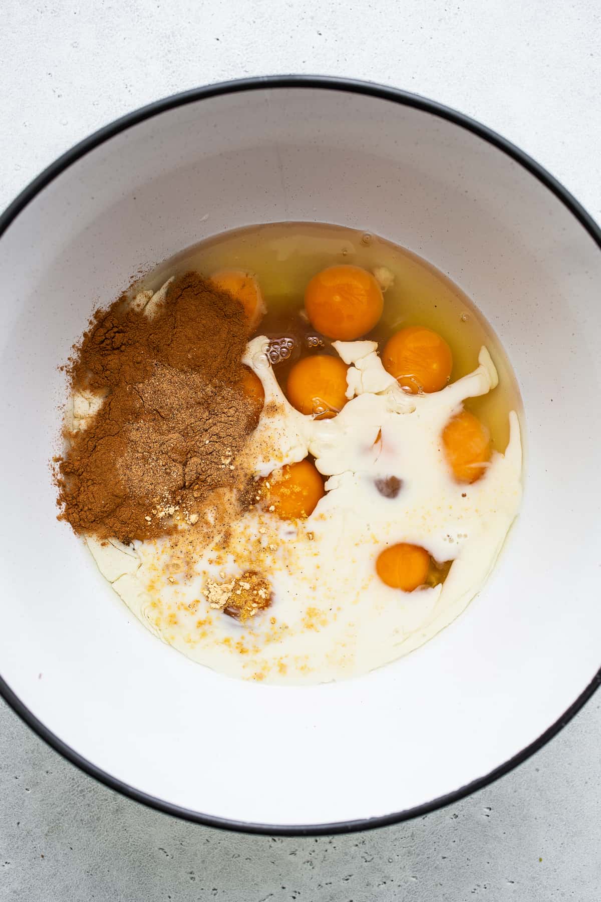 Eggs, milk and cinnamon in a bowl for carrot cake french toast casserole.