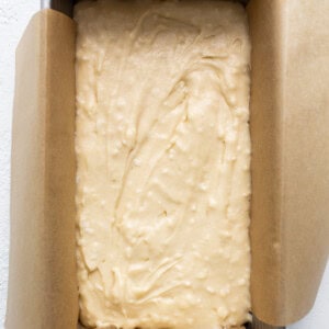 A cake in a baking pan on a white surface.