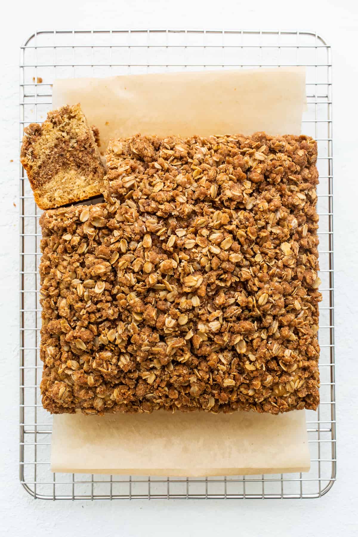 A piece of coffee cake sliced and cooling on a wire rack. 