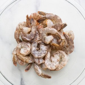 Shrimp in a glass bowl on a marble table.