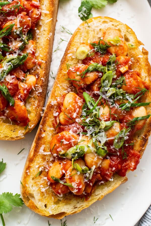 Chickpea and tomato bruschetta on a white plate.