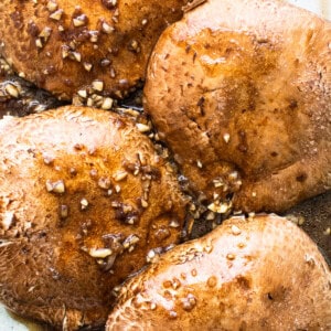 Chicken breasts in a baking dish with sauce and sesame seeds.