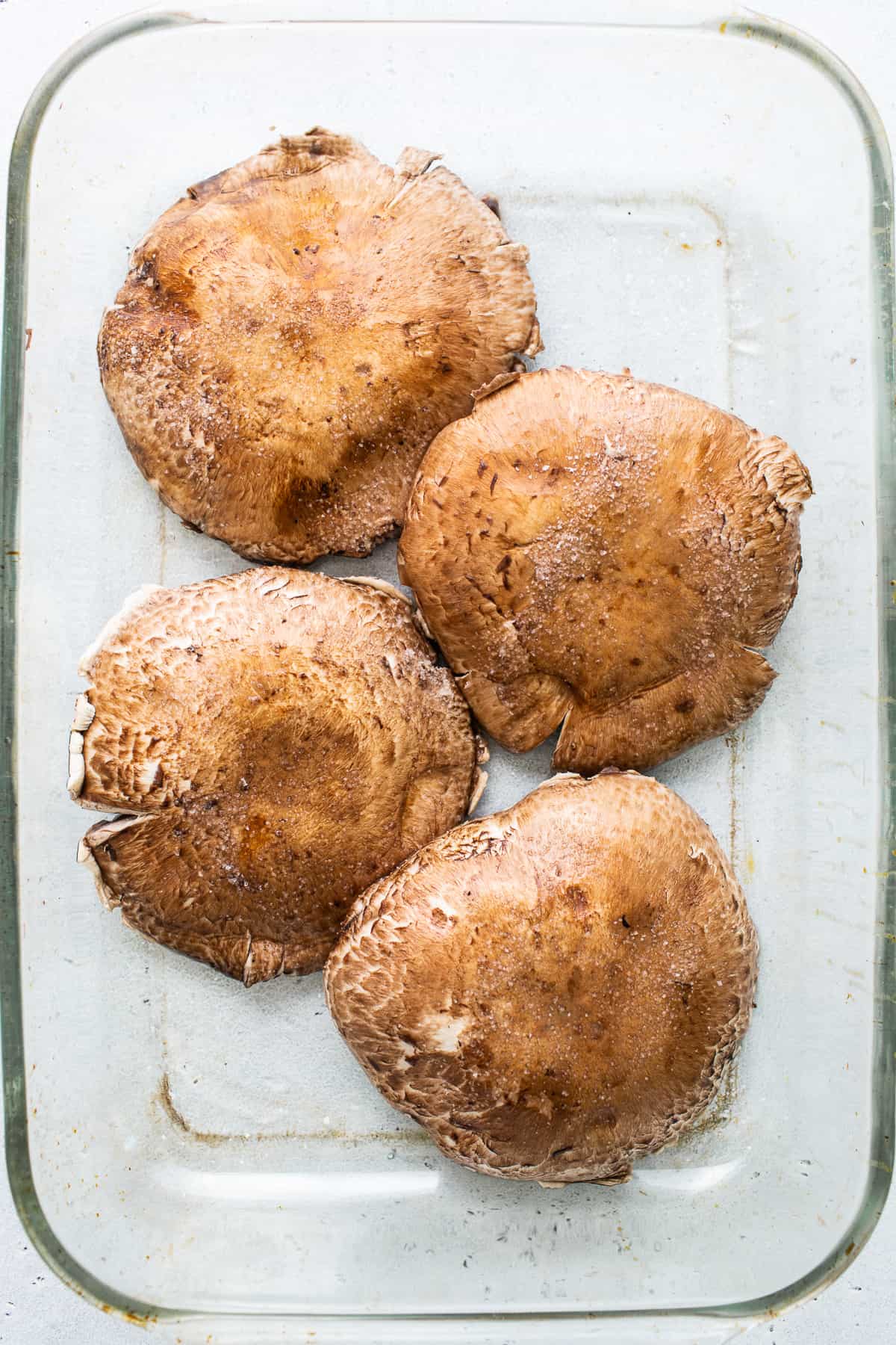 Portobello mushrooms in a baking dish.