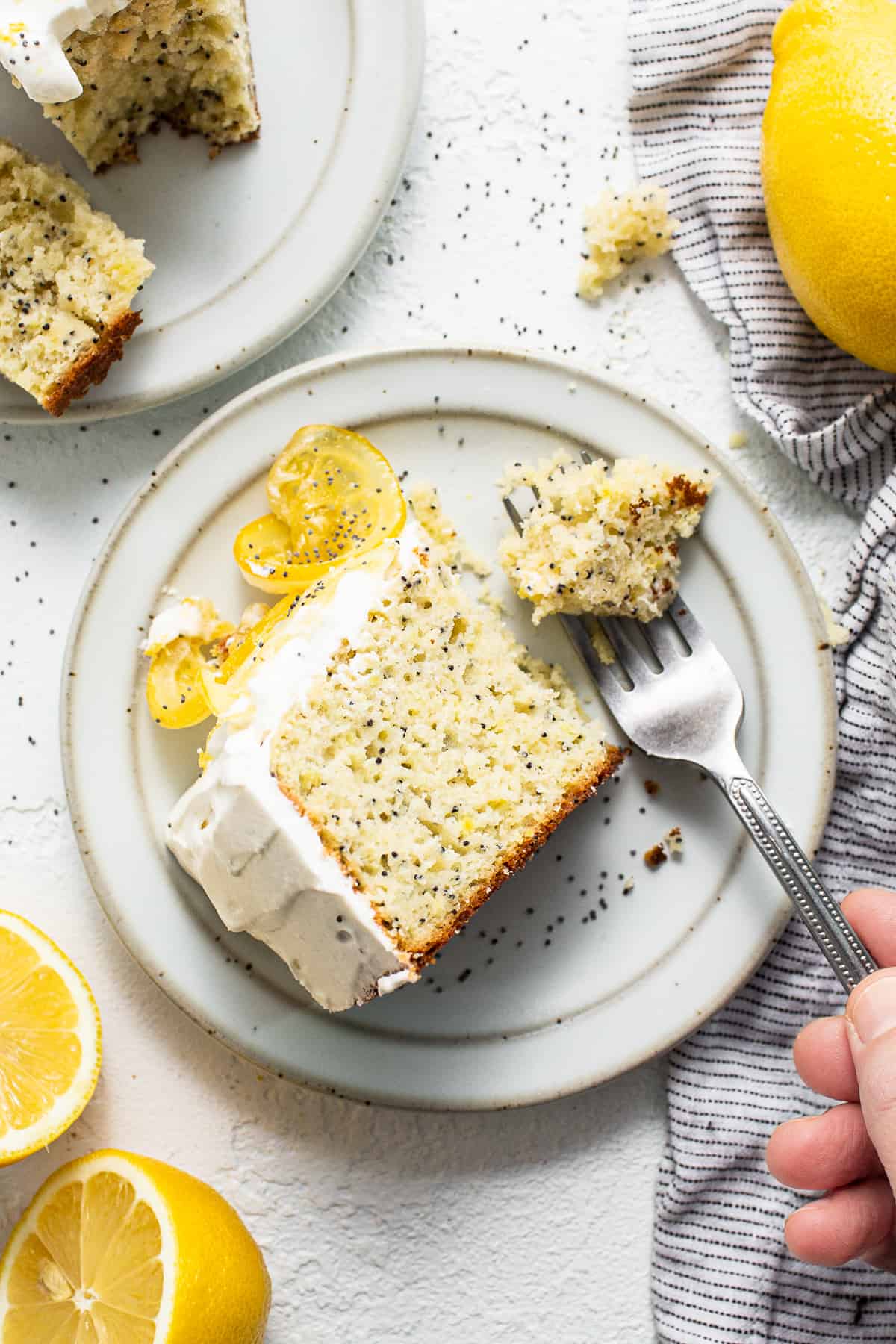 Slice of lemon poppy seed cake on a plate with a fork.