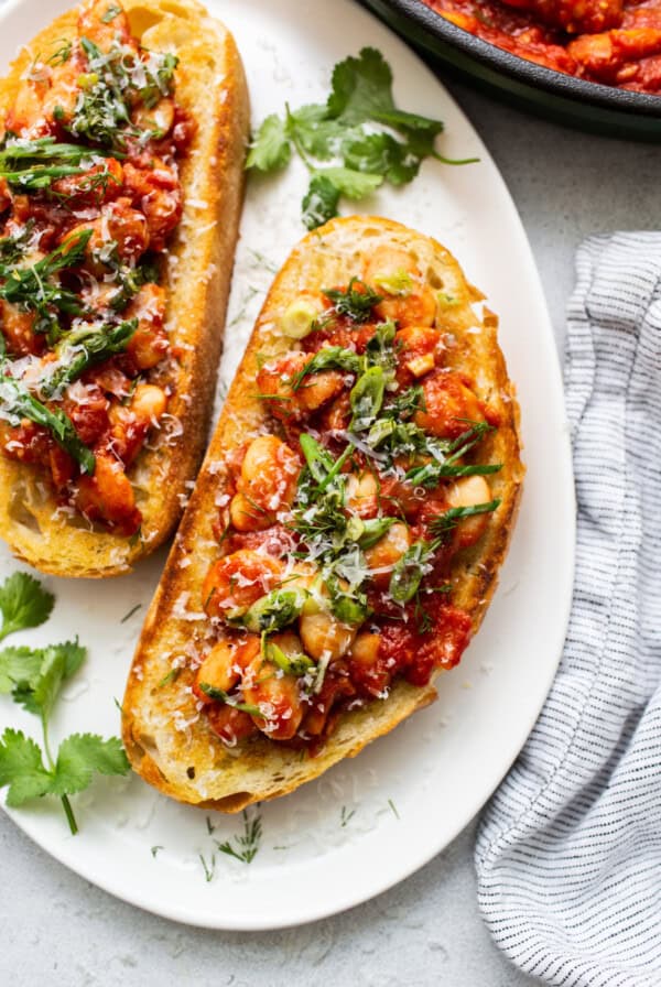 Two slices of bread topped with chicken and parsley.