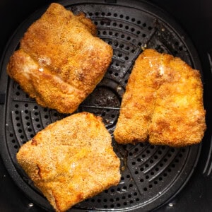 Air fryer fish in an air fryer basket.