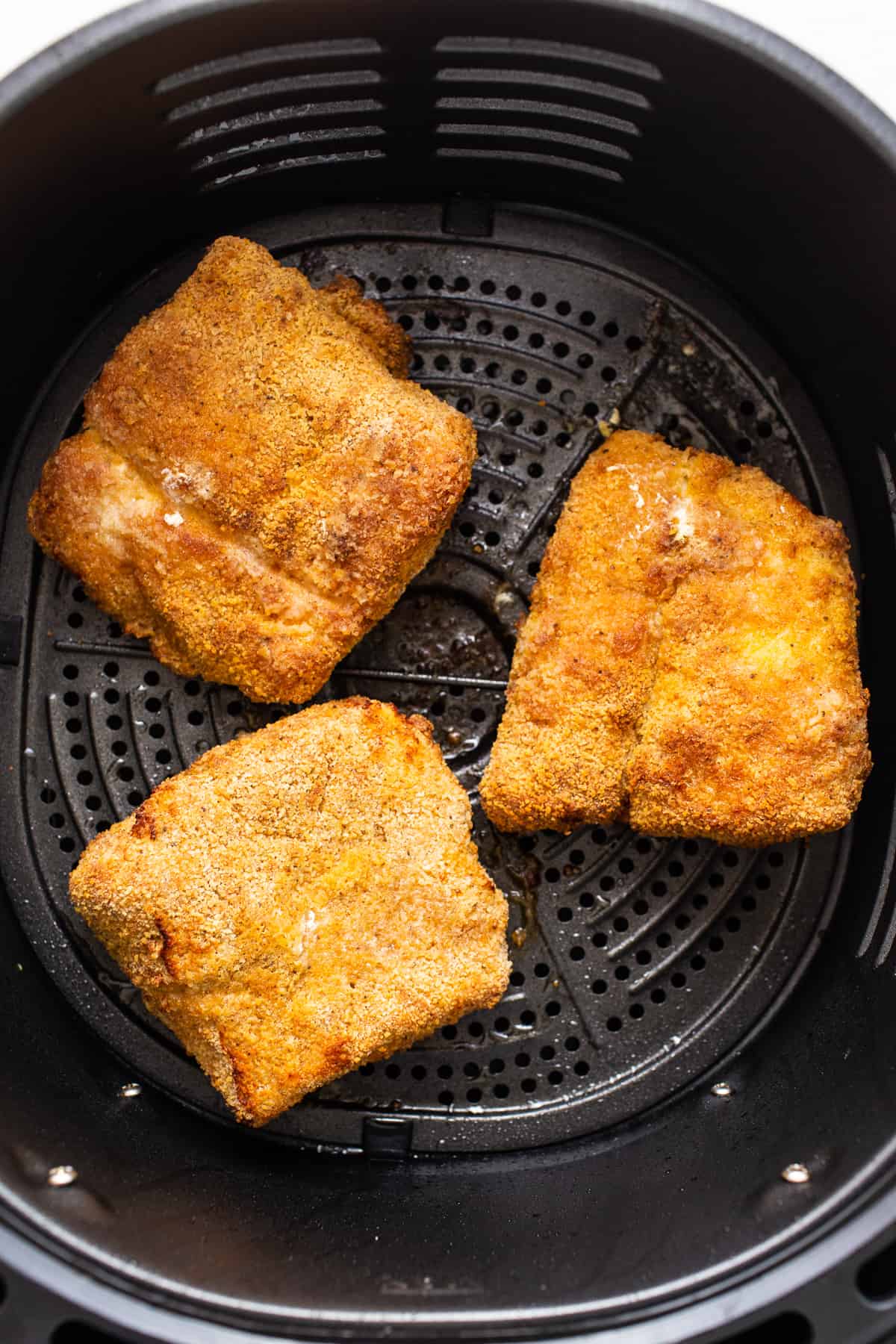 Air fryer fish in an air fryer basket.