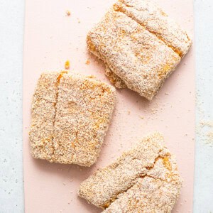 Three pieces of cookies on a pink cutting board.