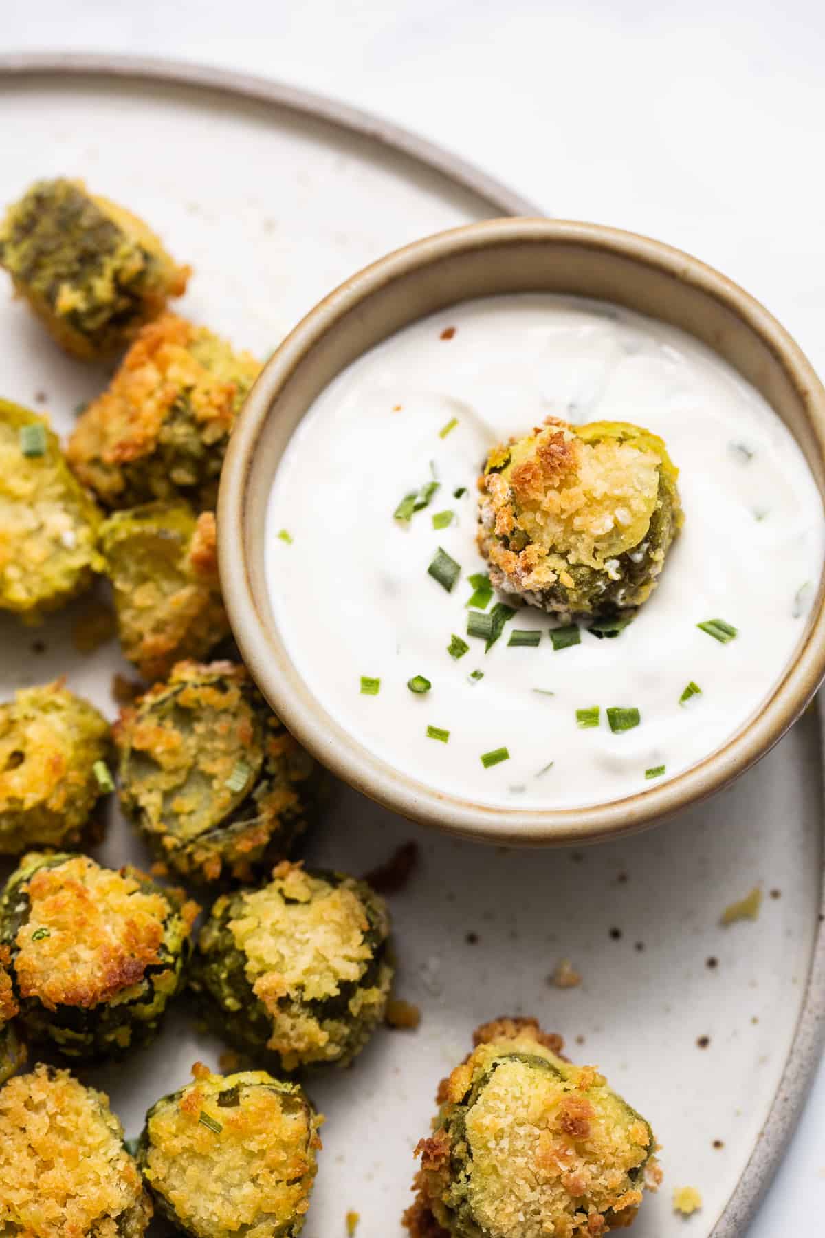 A plate of fried zucchini with dipping sauce.