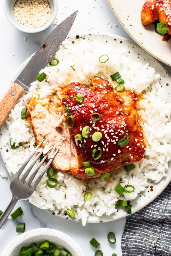 a white plate topped with rice and meat covered in sauce.