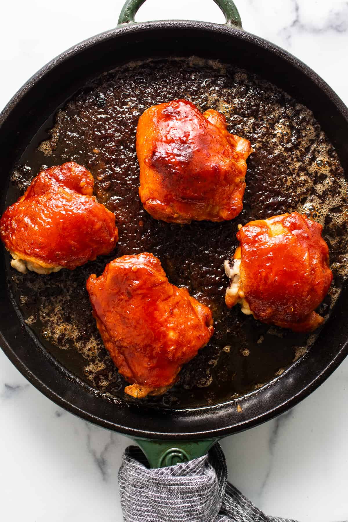 Saucy chicken thighs in a cast iron skillet.