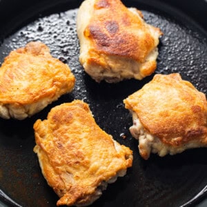 four pieces of food cooking in a skillet.