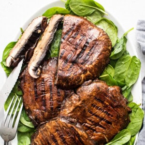 Grilled mushrooms and spinach on a plate.