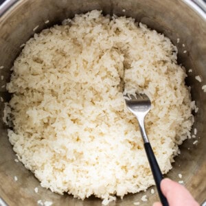 A person pouring rice into an instant pot.