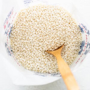 Buckwheat groats in a bowl with a wooden spoon.