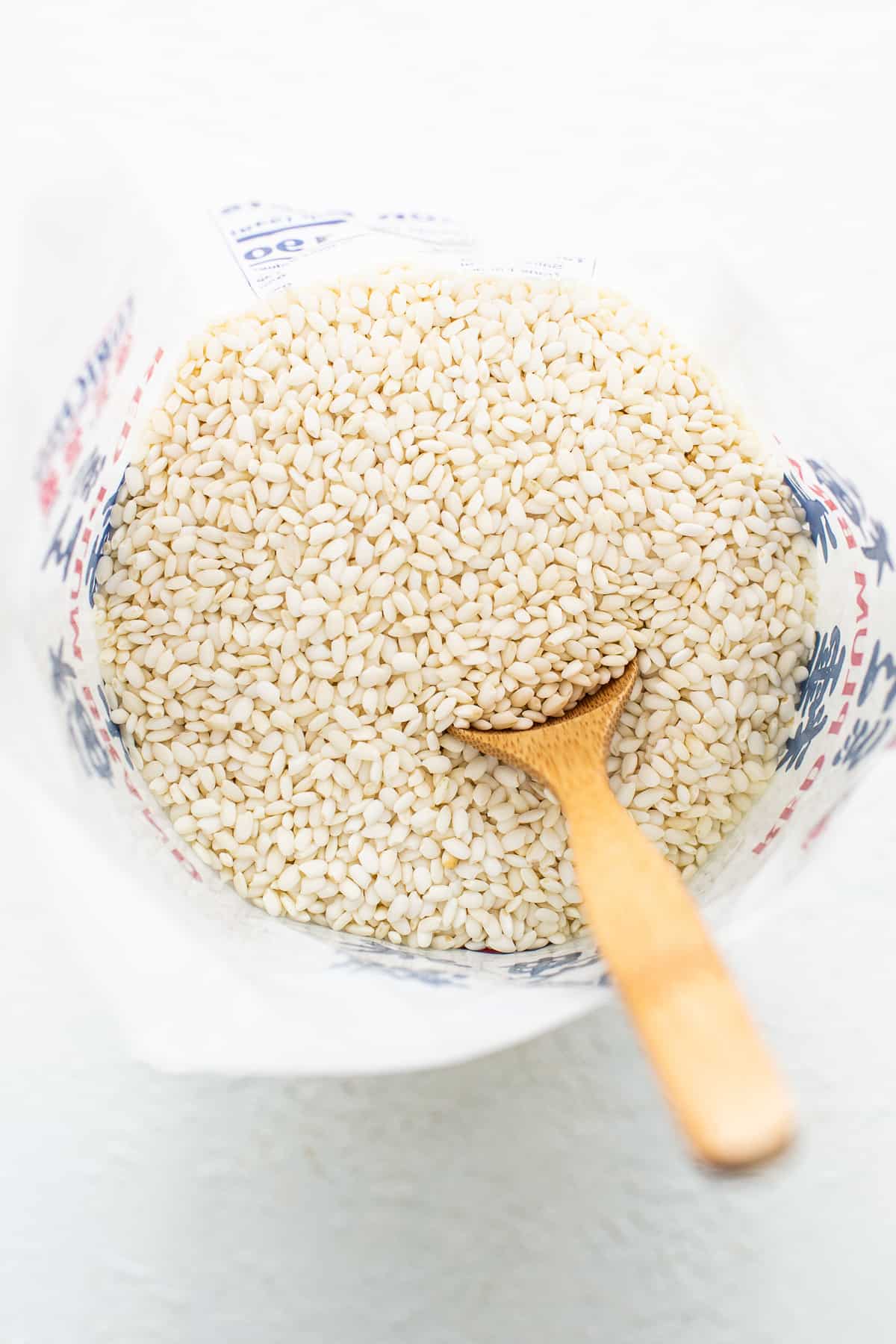 Buckwheat groats in a bowl with a wooden spoon.