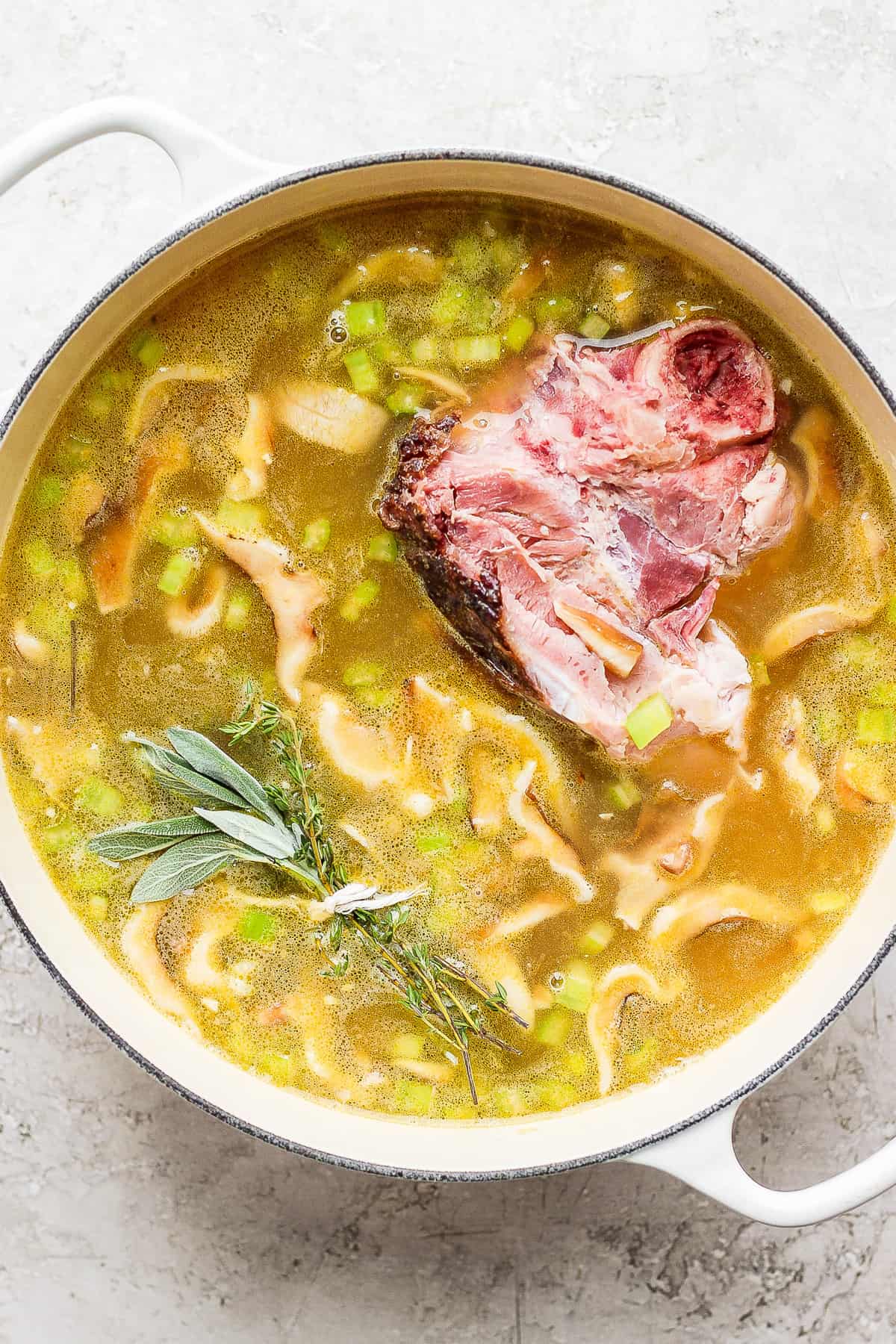 Split pea soup simmering in a dutch oven with a ham bone.