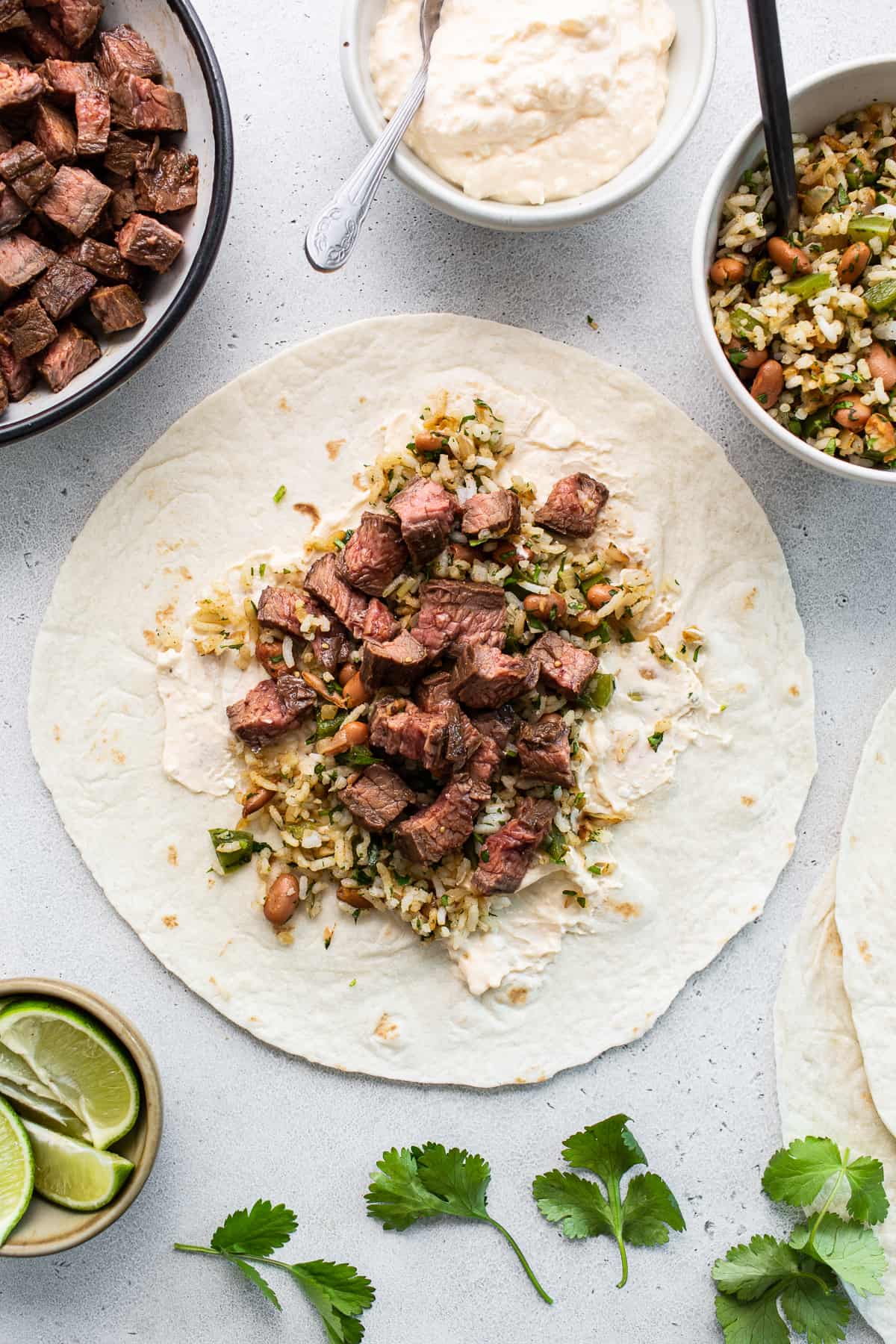 Steak burrito laid flat on a cutting board.