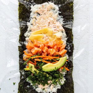 a sushi platter with salmon, avocado, carrots, and.