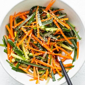 a white bowl filled with carrots and green beans.