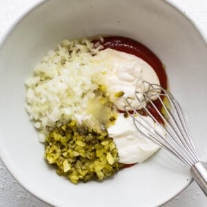 A bowl of ingredients with a whisk in it.