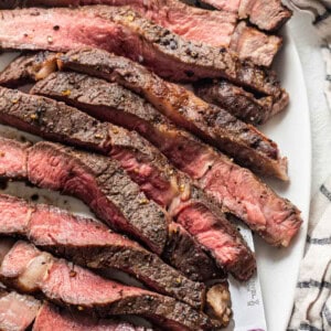 Air fryer steak on a white plate with a fork.