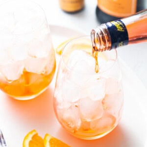 Aperol being poured into a glass for aperol spritz.