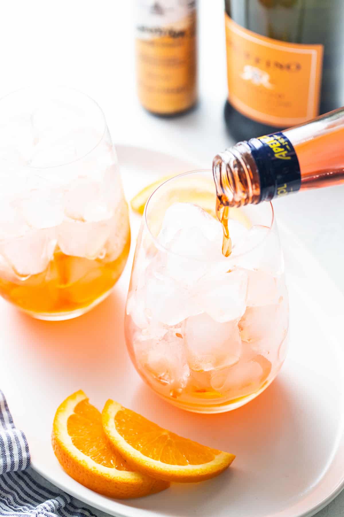 Aperol being poured into a glass for aperol spritz.