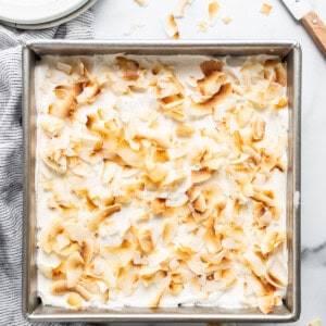 a pan filled with a dessert covered in coconut flakes.