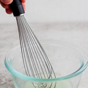 whisking fish marinade in a bowl.