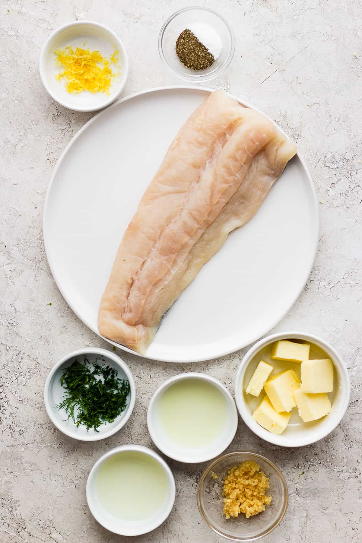 Grilled fish ingredients on a plate and in bowls.